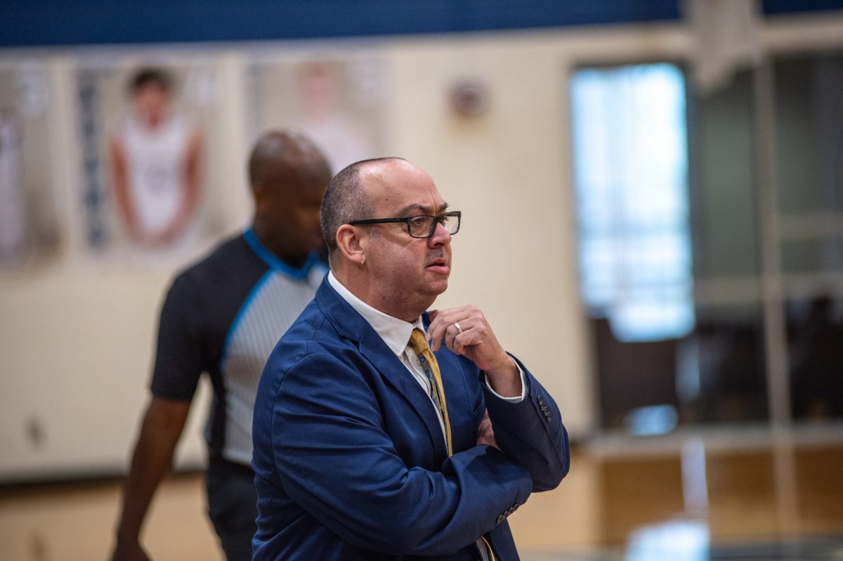 Women's basketball coach Ramiro Dominguez watches his team from the sideline in 2024.